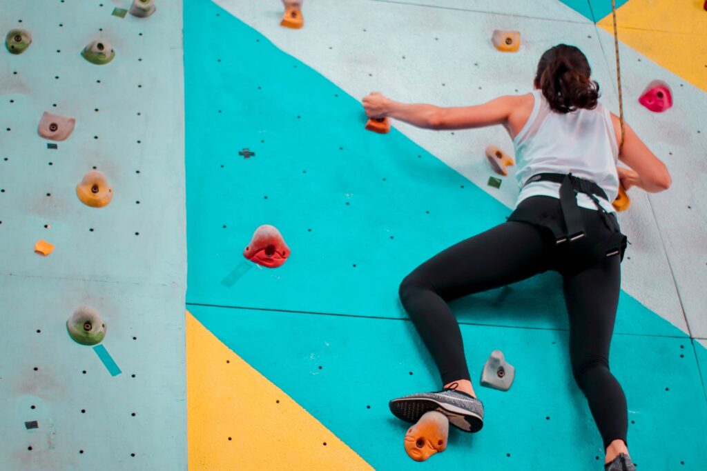 A woman climbing a blur wall