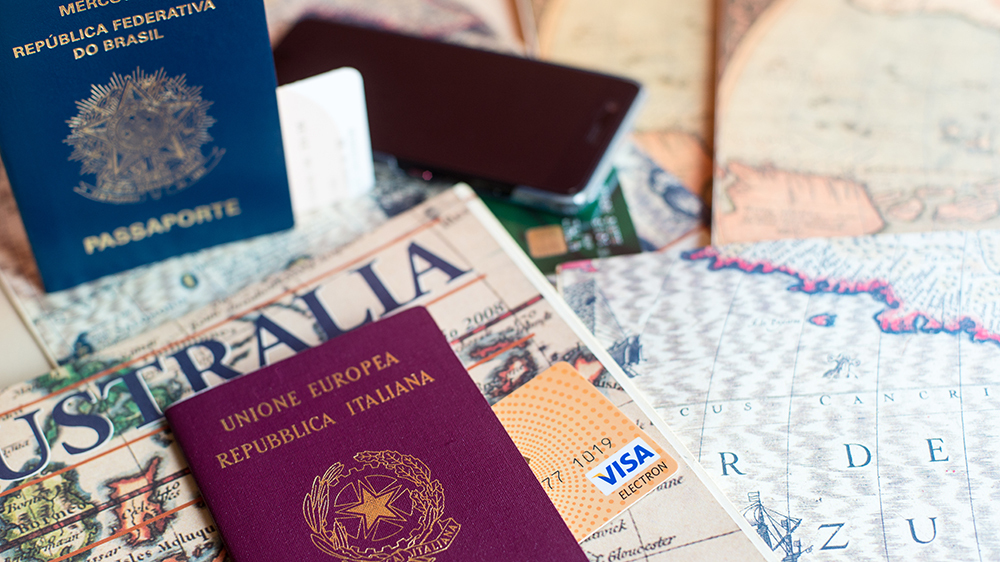 Milan, Italy – July 20, 2018 : An Italian and brasilian passports and a smartphone over a tourist magazine. Preparations for a trip in South America or Australia. Useful for travel agencies.; Shutterstock ID 1463680589; Notes: Robb Report—Passports