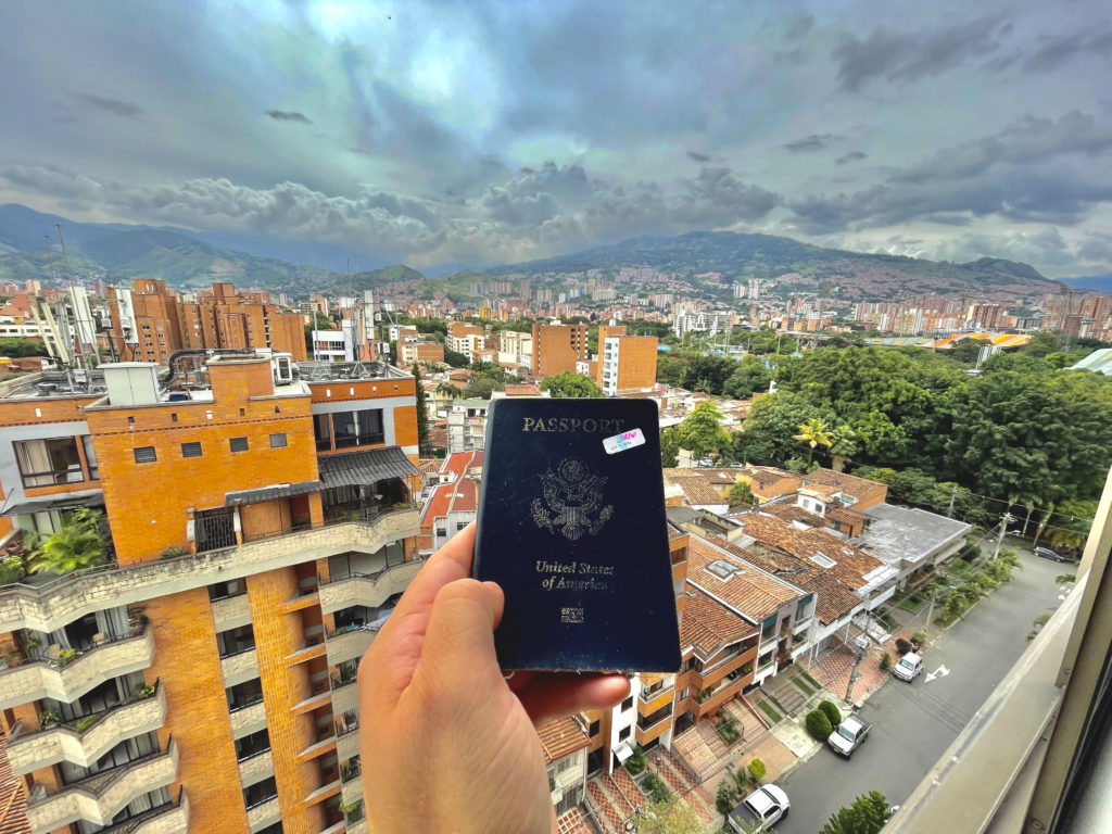 passport against medellin city backdrop